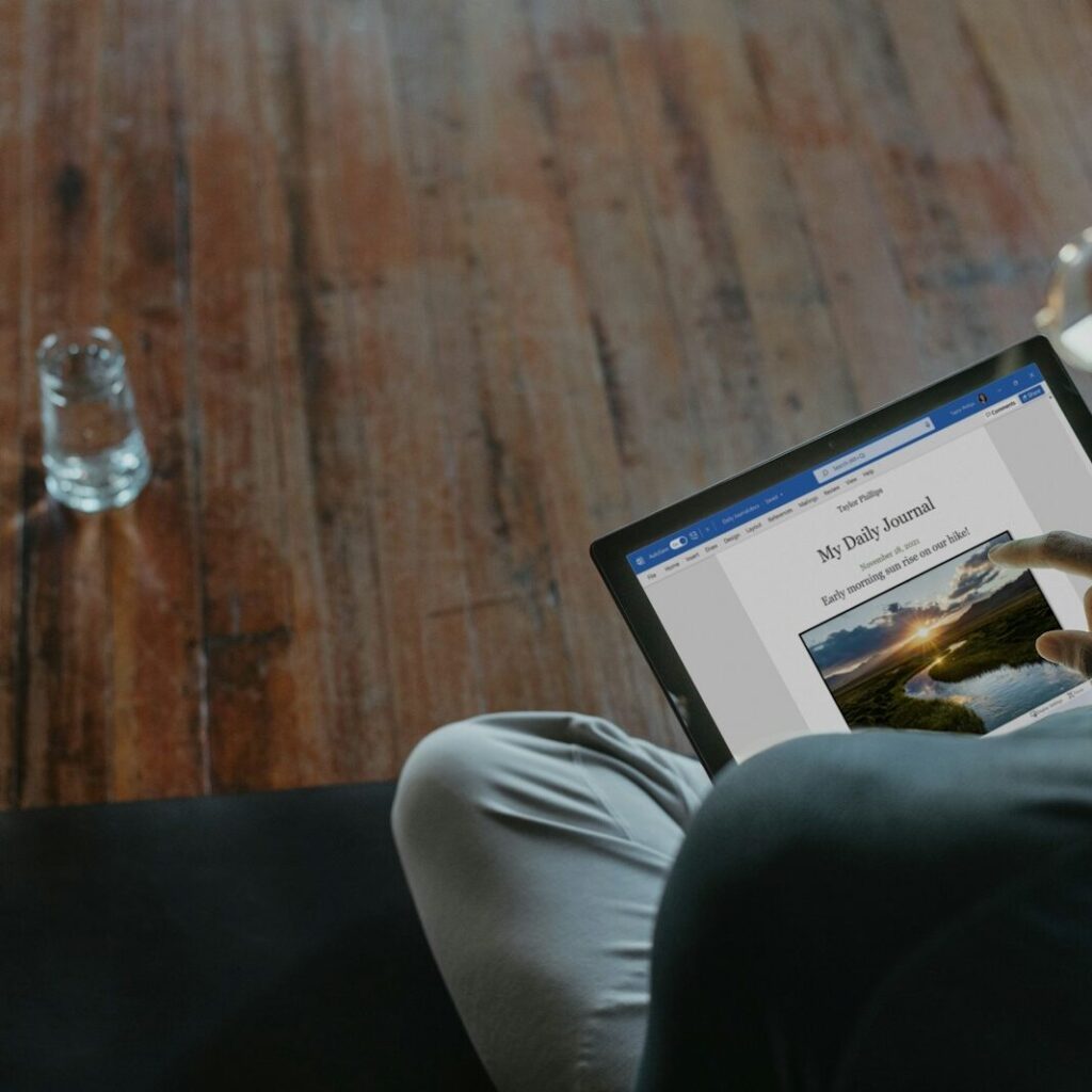 a man sitting on a couch using a laptop computer
